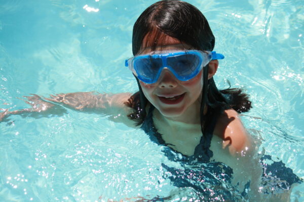 Petit fille dans la piscine de la colonie de vacances Neige et Soleil