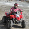 Petite fille sur un quad rouge en hiver