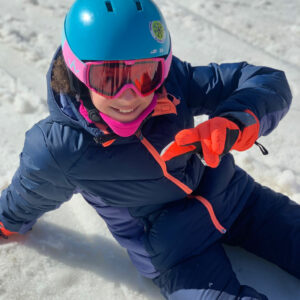 Petit fille assise dans la neige à la fin de sa seance de ski alpin en Haute Maurienne