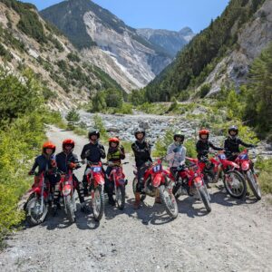 Groupe d’adolescents entierement equipes, posant avec leurs motos sur un chemin de montagne en Haute Maurienne durant l'ete