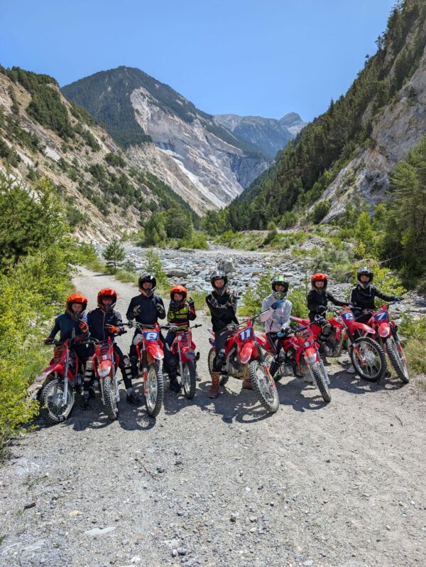 Groupe d’adolescents entierement equipes, posant avec leurs motos sur un chemin de montagne en Haute Maurienne durant l'ete