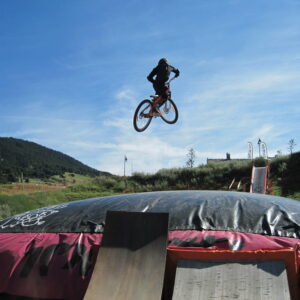 adolescent entrain de sauter avec son velo dans le big air bag