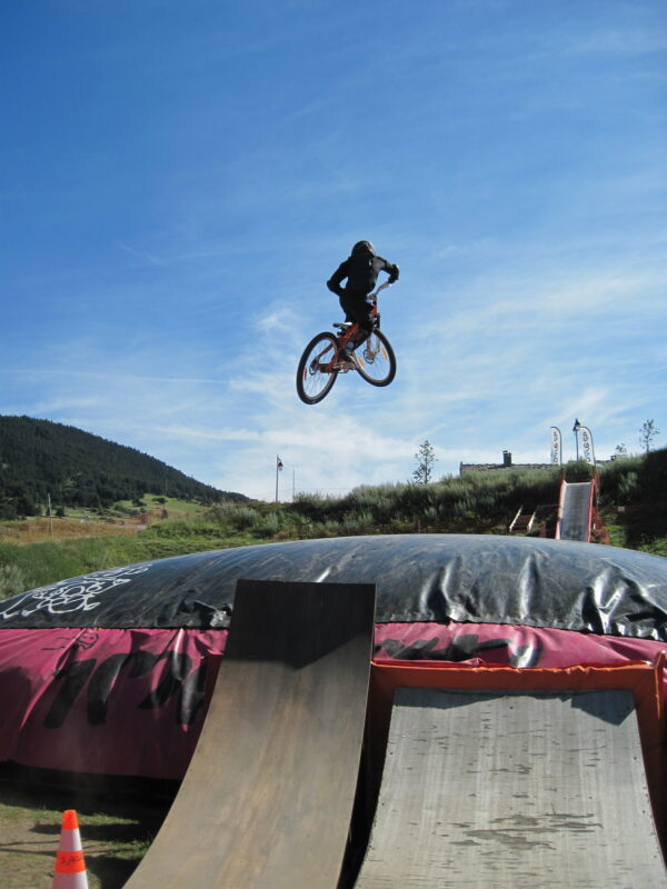 adolescent entrain de sauter avec son velo dans le big air bag