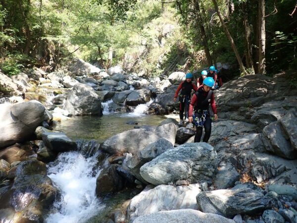 Groupe d'adolescents entièrement équipé pratiquant le Canyoning en Savoie lors d'une colo neige et soleil