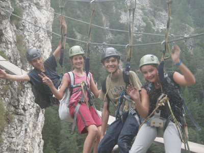 Enfants qui font de la via ferrata en Savoie. colonie de vacances pour enfants
